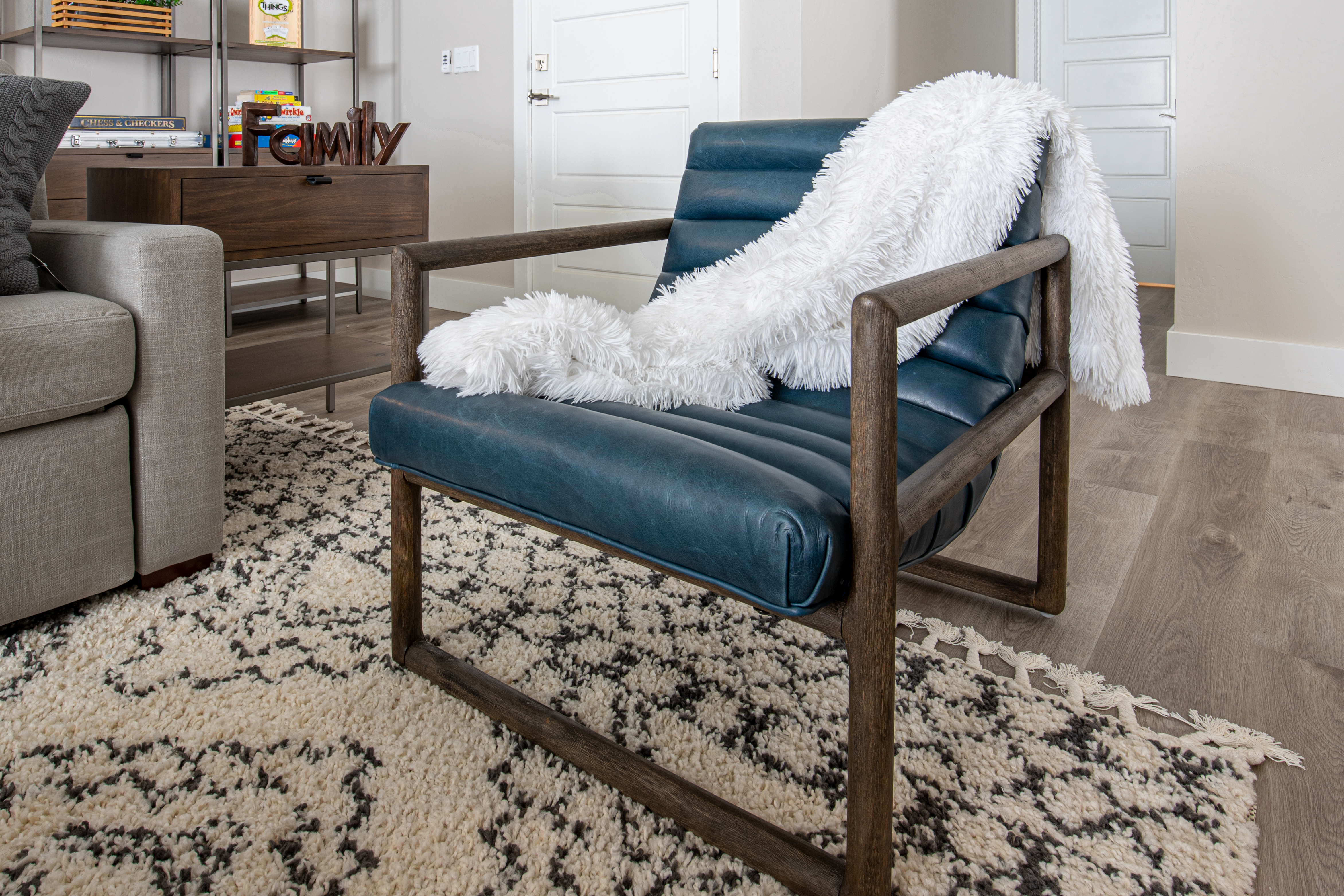 Blue leather chair with white throw blanket over it.